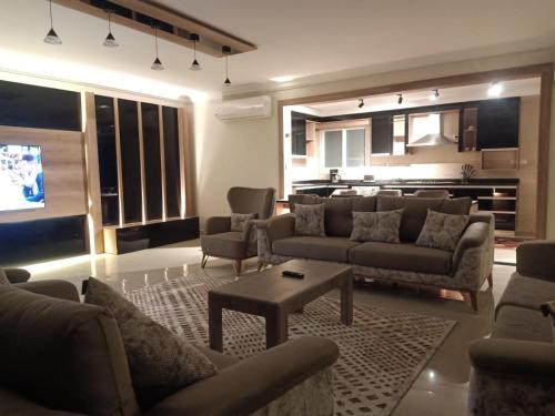 un salon avec des canapés et une table ainsi qu'une cuisine dans l'établissement Sheraton Ocean 704 - Without Pool access, au Caire