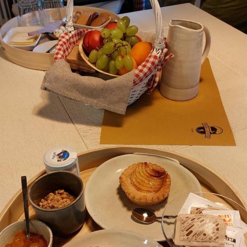 a table with a plate of food and a basket of fruit at BeB LUCA76 in Avise