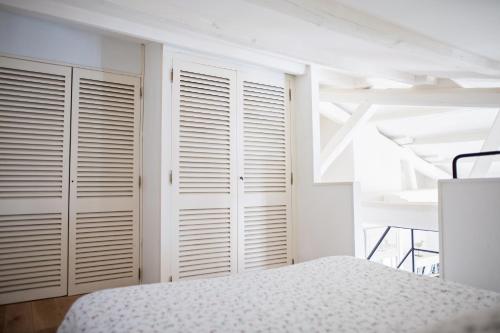 a bedroom with white closets and a bed at XVIII Century Gem With Magnificent Views Of The Harbour with a private garage in Saint-Martin-de-Ré