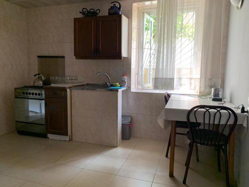 a kitchen with a stove and a table and a window at House 122 in K'obulet'i