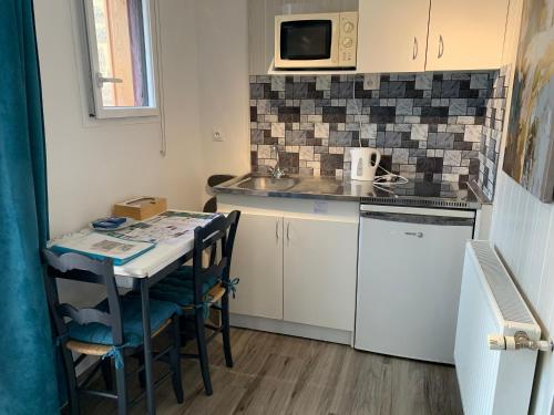 une petite cuisine avec une table et un micro-ondes dans l'établissement La Basse Monniere, à Sevremont