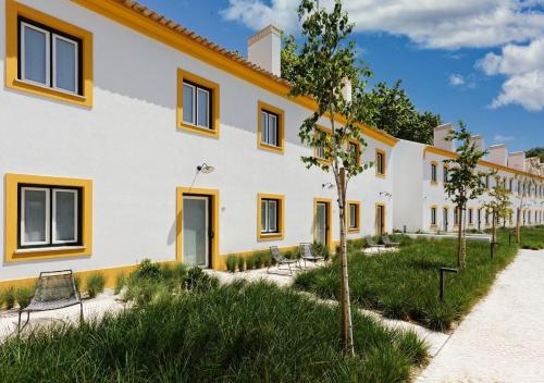 a large white building with yellow accents at Montebelo Vista Alegre Ílhavo Hotel in Ílhavo
