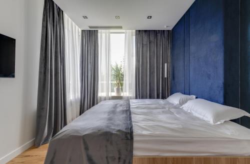a bedroom with a large bed with blue walls at BASIS APARTMENTS - Adults Only in Kyiv