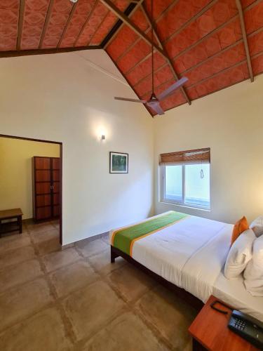 a bedroom with a large bed and a window at Abad Brookside Wayanad in Vythiri