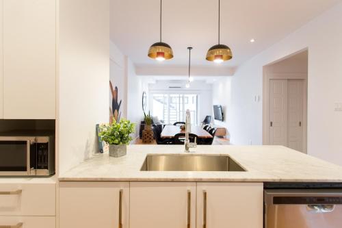 a kitchen with a sink and a counter top at Hip, Stylish Apartment in Little Italy by Den Stays A in Montréal