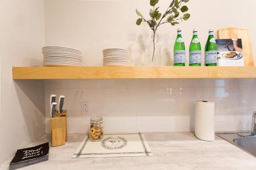 una cocina con botellas en un estante sobre un fregadero en Trendy Little Italy 3 Bedroom Condo by Den Stays en Montreal