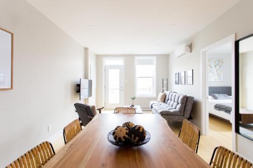 a living room with a wooden table and chairs at Trendy Little Italy 3 Bedroom Condo Free parking in Montréal