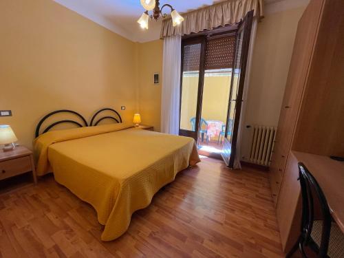 a bedroom with a bed with a yellow bedspread at Hotel Rabay in Brenzone sul Garda