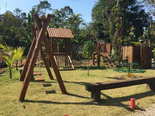 um parque com um parque infantil de madeira com escorrega em Trakai Suites em Ubatuba