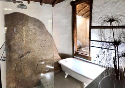 Un baño con bañera y ventana. en Refúgio Guest House, en Ilhabela