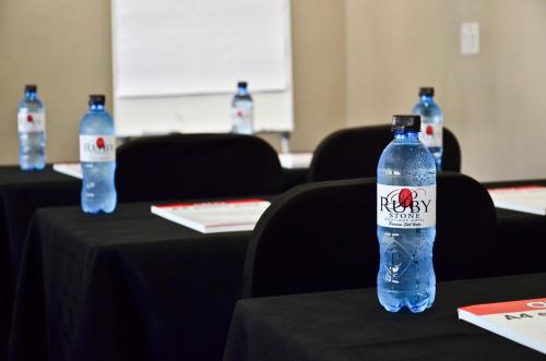 two bottles of water sitting on tables in a room at Ruby Stone Boutique Hotel in Polokwane