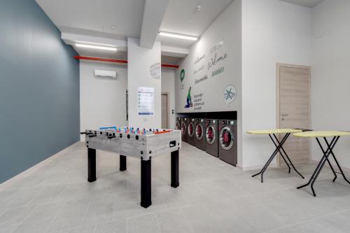 a ping pong table in a room with washing machines at Camplus Regio Parco in Turin