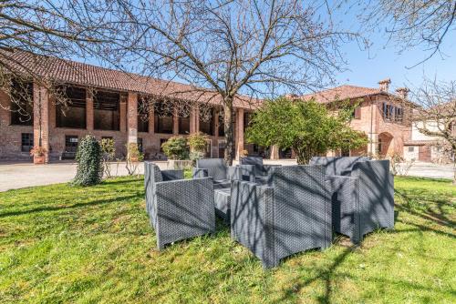 a group of chairs in the grass in front of a building at Marchesi Incisa Winery Lodge in Rocchetta Tanaro