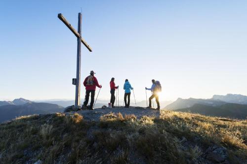 a group of people standing on top of a hill with a cross at Ferienwohnung Hain in Birnbaum