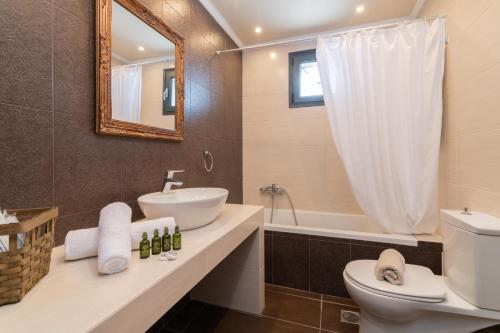 a bathroom with a sink and a toilet and a tub at Nimar Villa in Gaïtánion