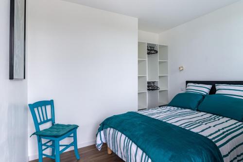 1 dormitorio con 1 cama y 1 silla azul en Bella Vista - Face mer La Baule - 5 personnes, en La Baule