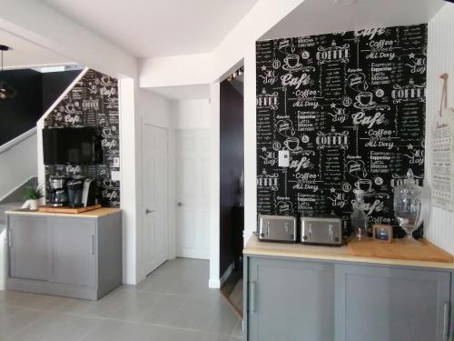 uma cozinha com uma parede preta com um quadro negro em Gîte Shoreline de la terre à la mer em Rivière-la-Madeleine