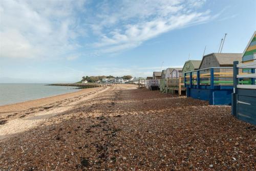 a beach with houses and the ocean at Home with sea views next to the beach! in Kent
