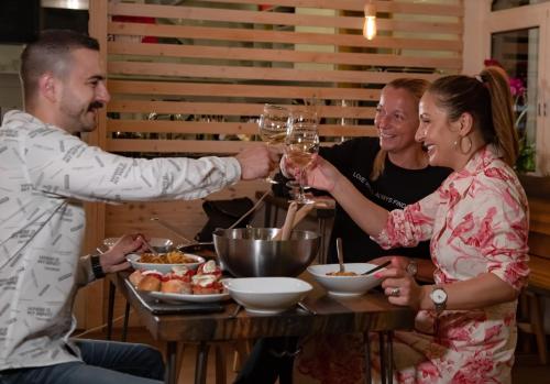 a group of people sitting around a table drinking wine at GRAND your home with common kitchens with self check-in in Engelberg