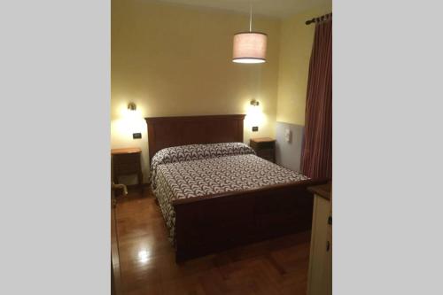 a bedroom with a bed and two lights on at Casa a schiera fronte lago con giardino in Barcis