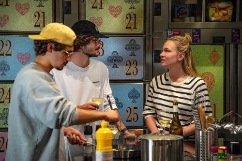 a group of people standing in a kitchen preparing food at GRAND your home with common kitchens with self check-in in Engelberg