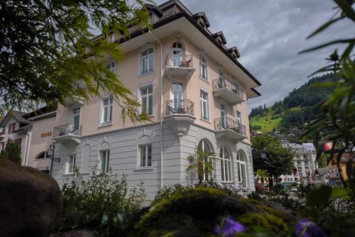 a large building with a clock on the front of it at GRAND Your home with common kitchens in Engelberg