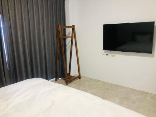a room with a bed and a television on a wall at 隱山行旅包棟民宿 in Puli