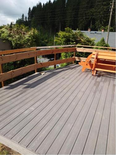 a wooden deck with a bench and a fence at Historisches Aschberg Haisl Klingenthal, Terrasse, großer Garten 6 plus 2 Personen in Klingenthal
