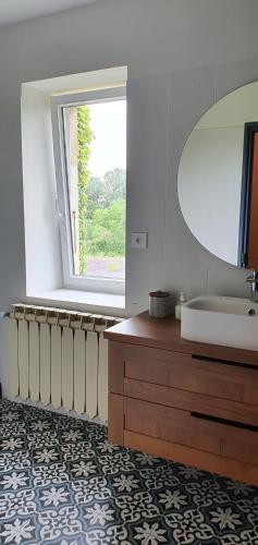 a bathroom with a tub and a sink and a window at La ferme du chateau in Puygiron