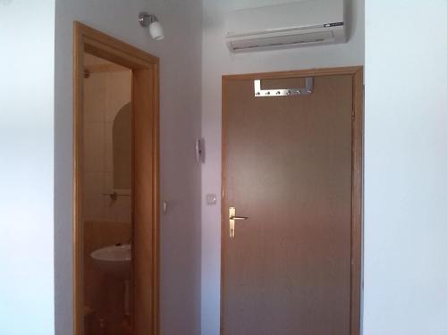 een deur naar een badkamer met een wastafel bij Guest House Andre in Međugorje