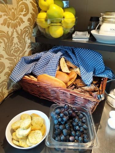 a basket of bread and grapes and a plate of food at Hotellilaiva Wuoksi in Kuopio