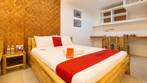 a bedroom with a bed with a book on it at RedDoorz at DBuilders Rooms Ph1 Taguig in Manila