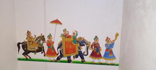 a painting of people riding horses on a wall at The Royal Lake View Villa in Udaipur