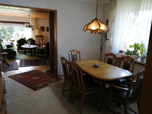 a dining room with a wooden table and chairs at Karolinenhof in Schüttorf