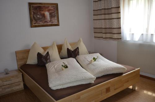 łóżko z białymi kocami i poduszkami w obiekcie Appartementhaus Eberharter w mieście Hart im Zillertal