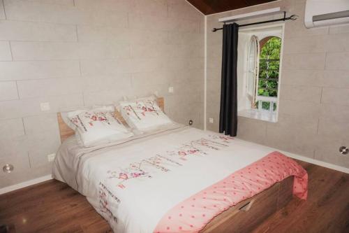 une chambre avec un lit blanc avec une fenêtre dans l'établissement MAGNANERIE LEONY : Maison au calme avec jardin, à Saint-Florent-sur-Auzonnet