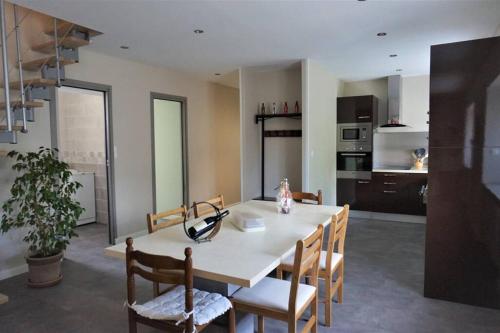 une salle à manger avec une table et des chaises et une cuisine dans l'établissement MAGNANERIE LEONY : Maison au calme avec jardin, à Saint-Florent-sur-Auzonnet