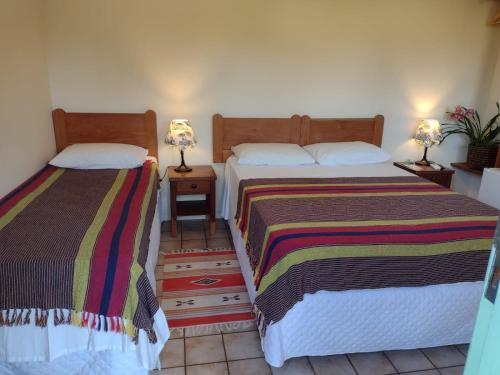 two beds sitting next to each other in a room at Pousada Ana Doce in São Sebastião