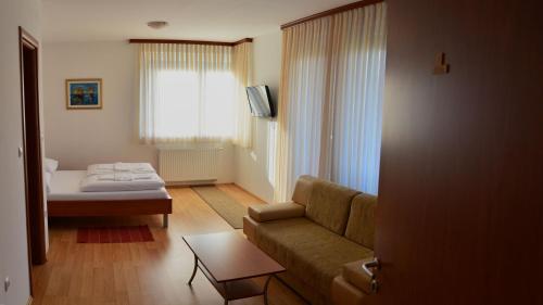 ein Wohnzimmer mit einem Sofa und einem Bett in der Unterkunft Rooms Funda Lepoglava in Ivanec