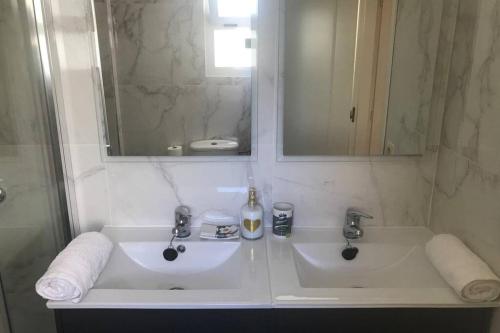 a white bathroom with two sinks and a mirror at Ático con terraza abierta/Open terrace apartment in Mijas
