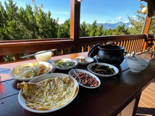 una mesa con platos de comida en el balcón en Lala Maple Villa, en Hualing