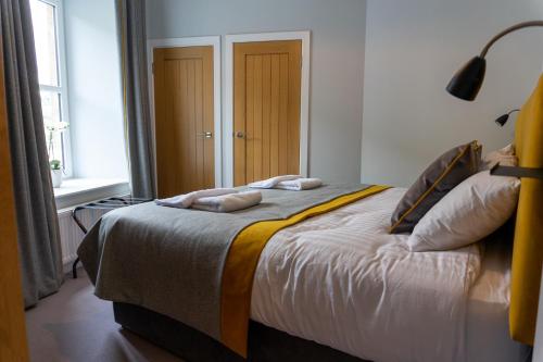 a bedroom with a bed with two towels on it at Airds Apartments in Oban