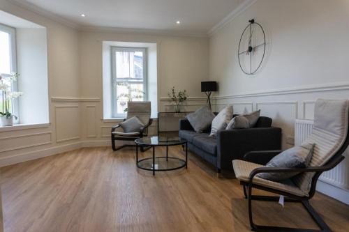 a living room with a couch and two chairs at Airds Apartments in Oban