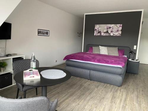 a bedroom with a bed and a table and a couch at City-Apartment Dülmen in Dülmen