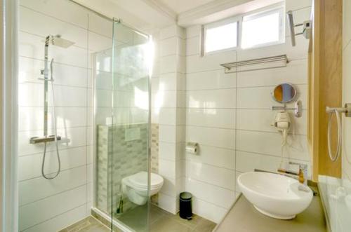 uma casa de banho com um chuveiro, um WC e um lavatório. em Q-Inn Boutique Hotel em Paramaribo