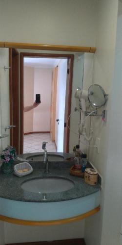a bathroom counter with a sink and a mirror at Apart Hotel Quartier Latin in Vitória