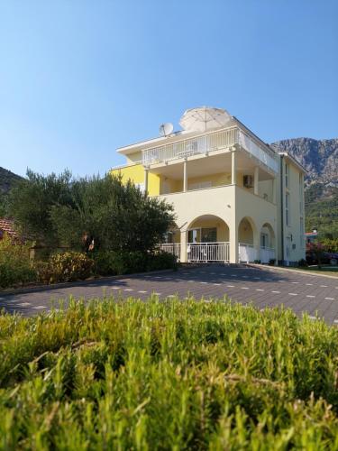 a large white building with a roof at Apartments Dia in Zaostrog