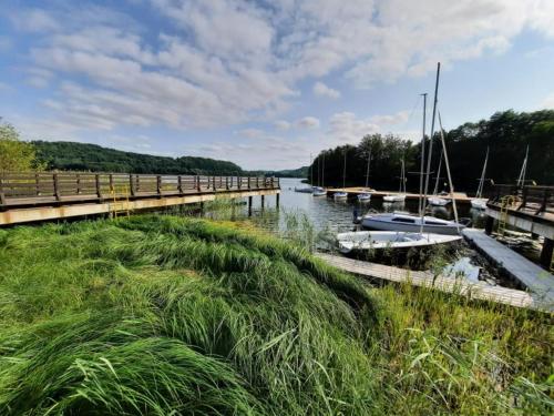 a bridge over a river with boats in the water at ZACISZE Domek na Kaszubach Brodnica Dolna z balią z jacuzzi na wyłączność w cenie in Brodnica Dolna