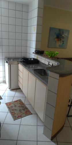 a kitchen with a sink and a counter top at Apart Hotel Quartier Latin in Vitória