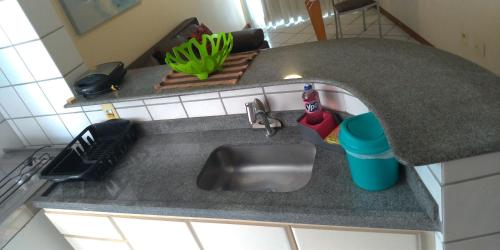 a kitchen counter with a sink and a plant at Apart Hotel Quartier Latin in Vitória